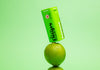 A green tin from Drops Candies containing 100mg of THC edibles, posed as if it is balanced on top of a lime.